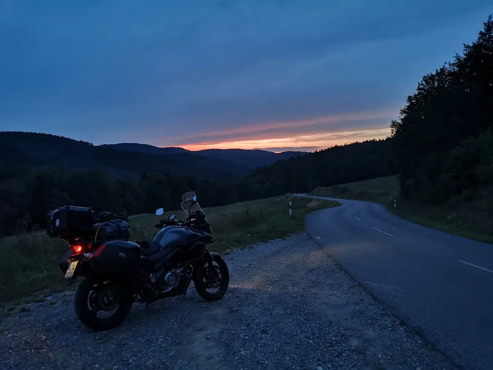 Motorrad am Rand einer kurvigen Landstraße in der Dämmerung